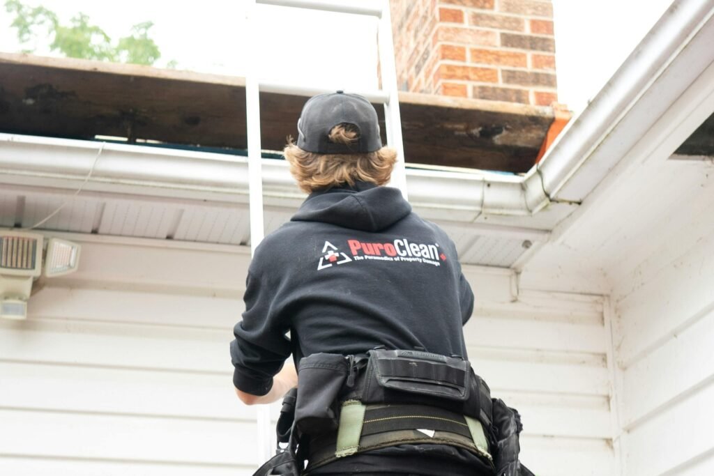 Man climbing ladder on home
